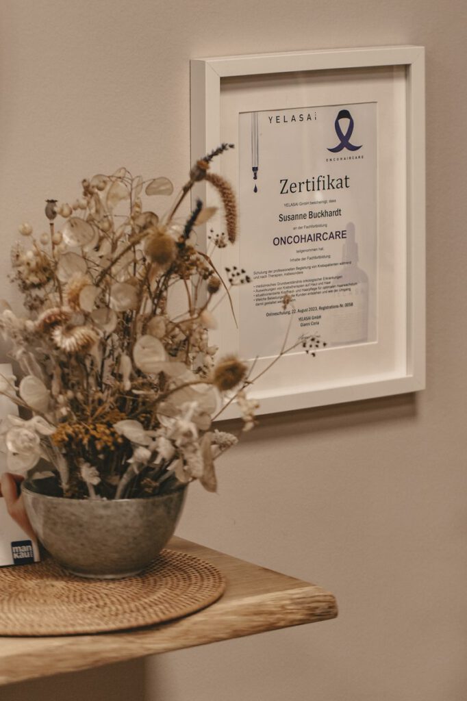 Gerahmtes Oncohaircare-Zertifikat von YELASAI mit Trockenblumen im Studio Schwungkraft